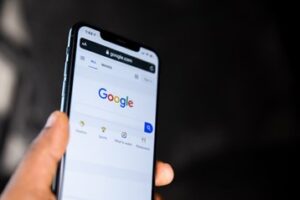 Why You Need an SEO Strategy - Google's home page on a smartphone. An SEO strategy increases the amount of website traffic that originates from Google.