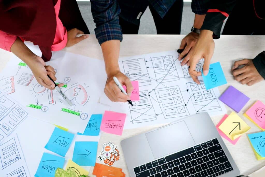 A small marketing team gathers around a table to discuss static websites and how to optimize a static site for SEO purposes. 